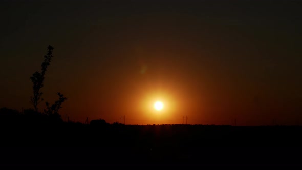 4K Beautiful sunset. The sun goes down below the horizon. Time lapse. Red sunset.