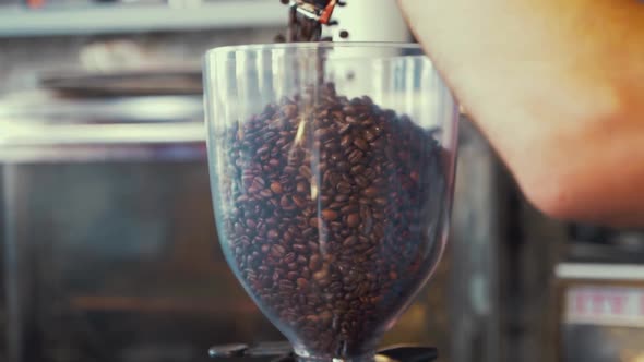 Coffee beans being poured into hopper in slow motion