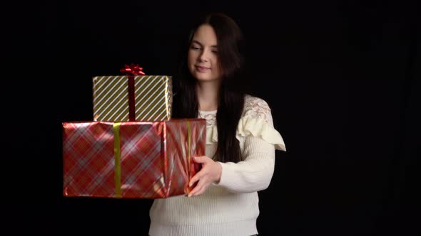 Young Woman with a Gift Box on Black Background, Gift Box with White Ribbon for Happy New Year