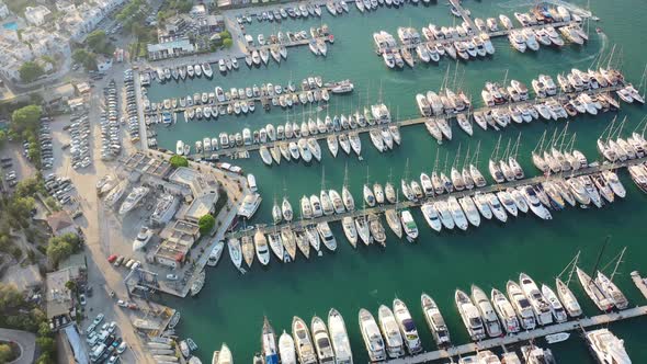 Aerial top down view of sailboats docked in the Bodrum marina with turquoise green water on a sunny