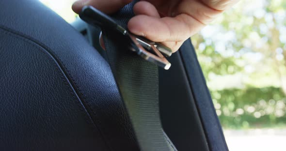 Hand holding seat belt of car