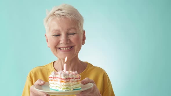 Old Woman Blowing out Candle on Birthday Cake