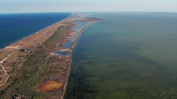 Flight on a quadrocopter over salt lakes, the sea. Coastline and little vegetation.