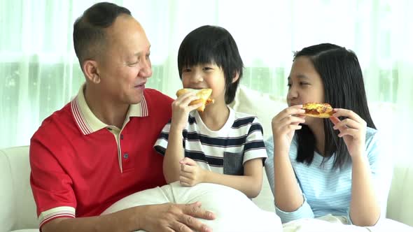 Asian Family Eating Pizza Together At Home