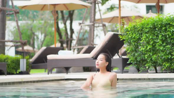 Young asian woman enjoy around outdoor swimming pool for leisure