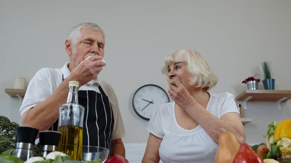 Elderly Grandparents Eating Raw Broccoli and Cauliflower. Vegetarian Diet. Healthy Senior Family