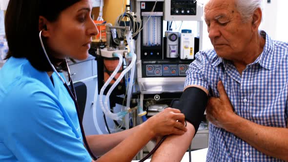 Female doctor checking blood pressure of patient