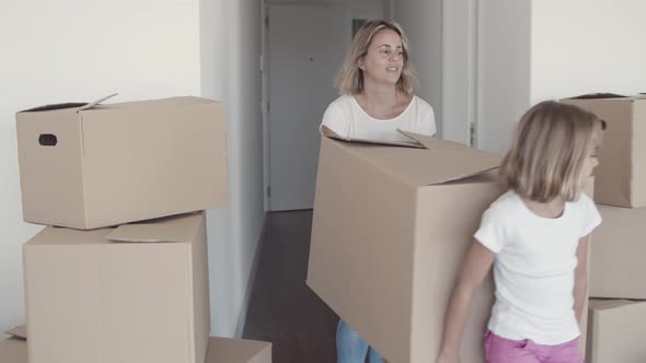 Positive Mom and Daughter Carrying Cartoon Box