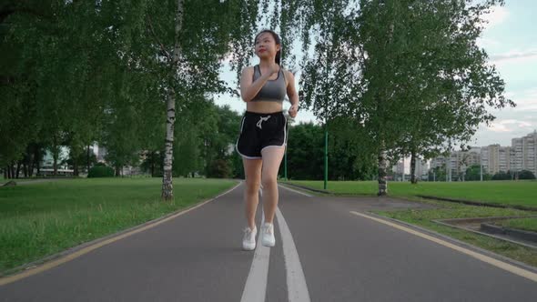 Asian Young Beautiful Woman Running for Health in the Evening Sunset on Street in Public Park