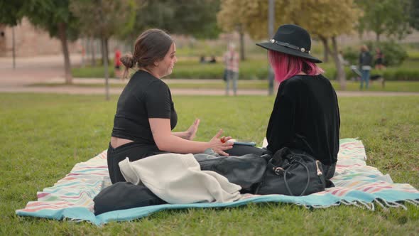 Side View of Two Girls on Black Clothing Interacting at the Park Area