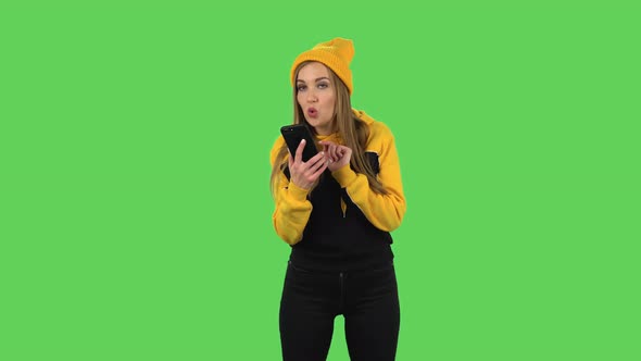 Modern Girl in Yellow Hat Is Asking for Information on the Network Via Phone. Green Screen