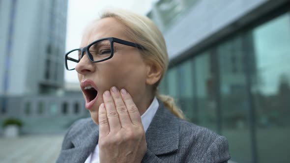 Blond Woman in Suit Looking at Teeth Reflection on Smartphone Screen, Caries