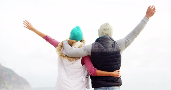 Couple standing with arms outstretched