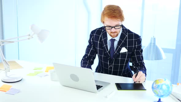 Redhead Designer working with Drawing tablet for a Computer