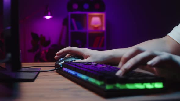 Gamer Typing on Backlight Keyboard Closeup Man Playing Video Game