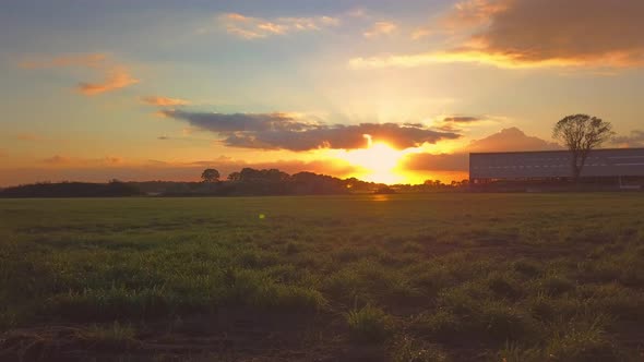 Aerial Cinematic Clip Drone Flying Over a Farm Field During Sunset