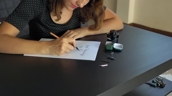 Close Up Shot of a Young Woman Calligraphy Writing on a Paper Using Lettering Technique. She Writtes