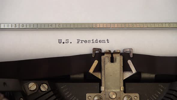 Typing phrase U.S. President on retro typewriter. Close up.