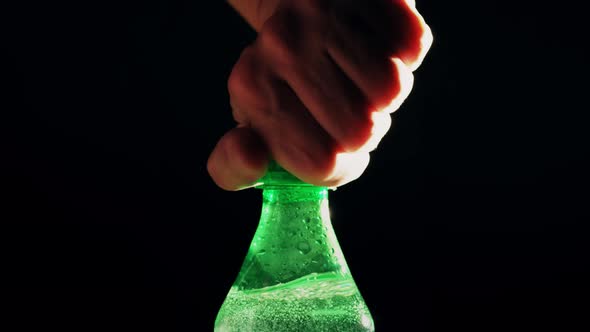 Man Opens Green Plastic Bottle of Foamy Soda