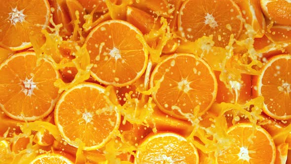 Super Slow Motion Shot of Fresh Orange Juice Splashing Through Orange Slices at 1000Fps
