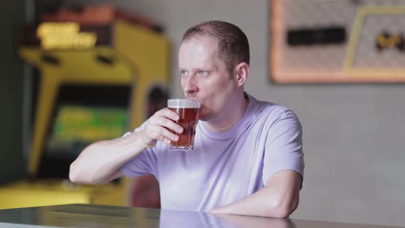 Young Man Drinking Beer a Bar