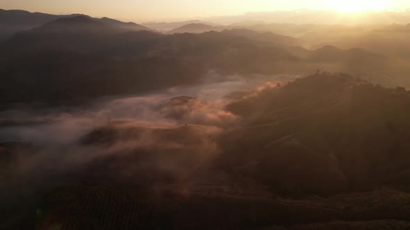 4K Scenic flight over beautiful mountain scape with bright sky and clouds