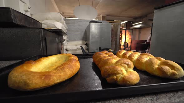 baked pastries in form of rolls and bread lie on table against background bakery