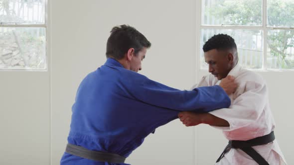 Judokas training by doing a randori on the judo mat