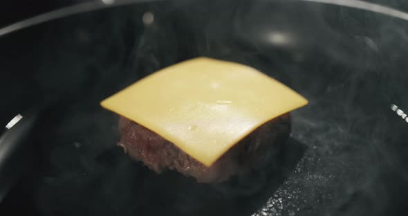 Chef Preparing the Burger, Frying the Meat with Melted Cheese on the Pan. Frying Cheeseburger Meat