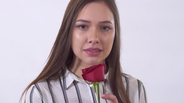 Portrait of Sad Young Woman, Crying in Studio Close Up. Lady Holding Rose in Hands. Shooting in the