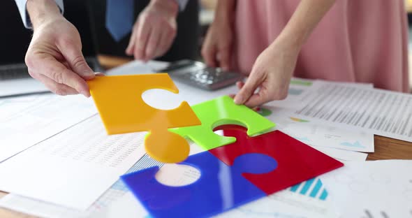 Business People Putting Together Colorful Puzzle at Table in Office Closeup  Movie Slow Motion