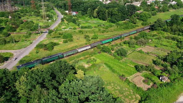 Aerial view of cargo train. Aerial view from above of railroad through green forest