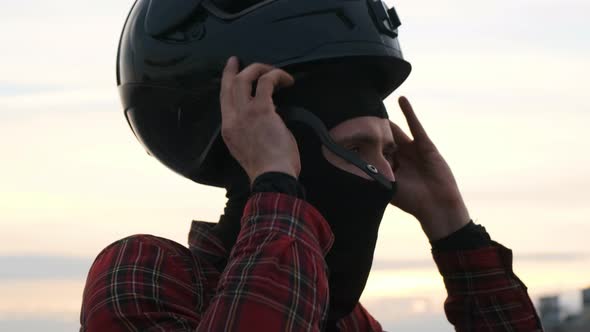 Close Up Footage Male Biker in Red Shirt Put on Motorcycle Black Helmet. Concept of Safety Driving