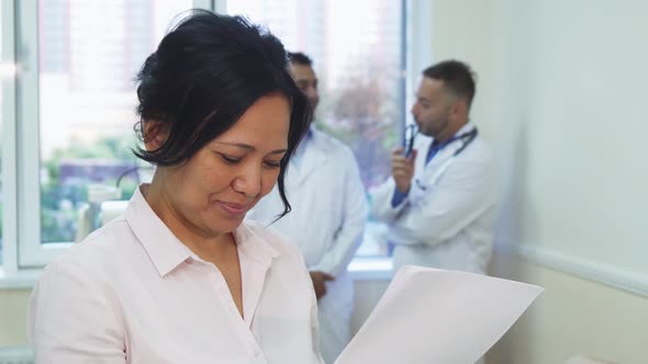 A Happy Patient Is Studying Her Medical Test Results