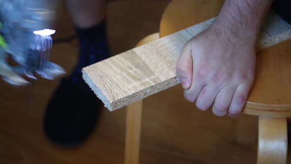 The Man Saws Off A Piece Of Board With An Electric Jigsaw Home Work With Furniture