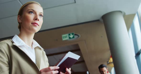 Woman holding passport and air ticket at airport