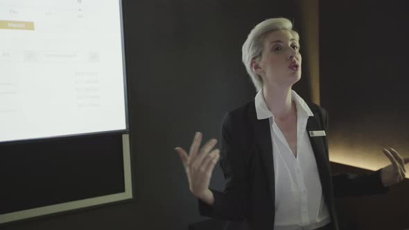 Businesswoman explaining presentation on projection screen