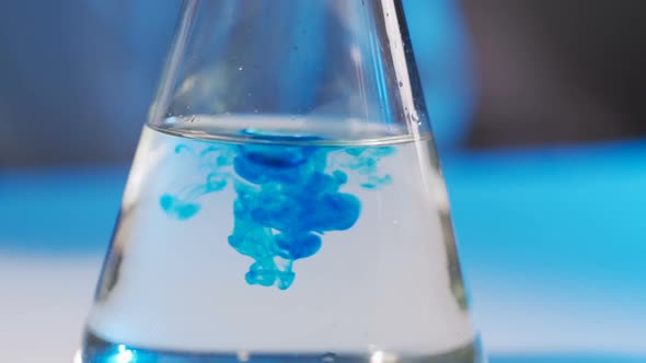 Laboratory Worker Scientist Laboratory Assistant Tests Chemicals for Reactions in Flask, Interfering alt
