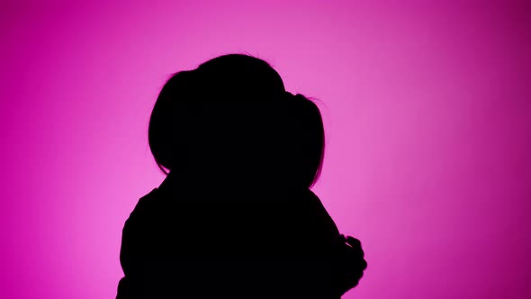 Two Women Hugging on Pink Neon Background