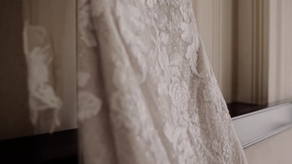 the bride's wedding dress is hanging in the room on the bed