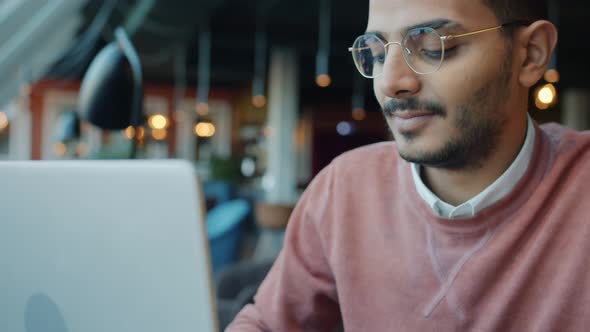 Middle Eastern Freelancer Working with Laptop Computer Infoors in Modern Cafe