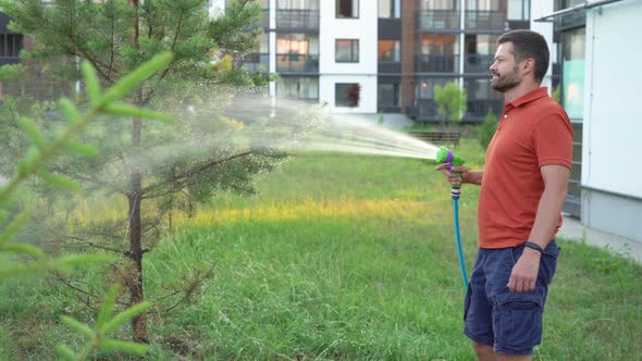 Man watering backyard lawn