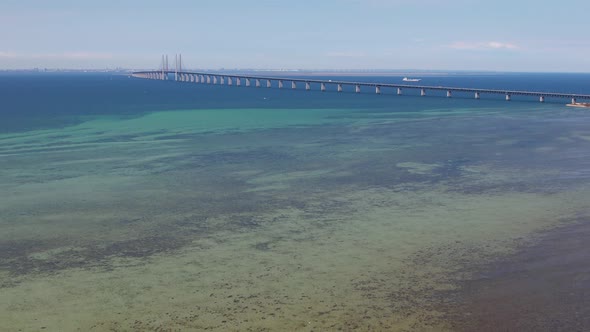 Aerial view of Øresundsbron from Sweden to Denmark from far, shallow water