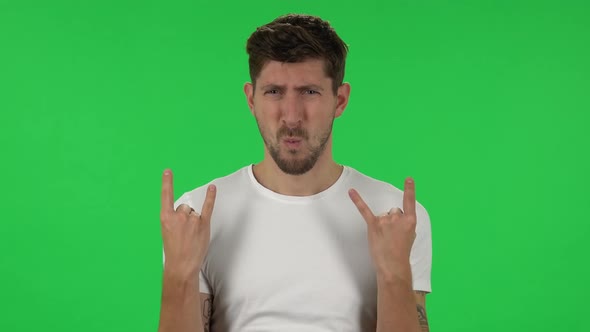 Portrait of Confident Guy Is Making a Rock Gesture and Enjoying Life