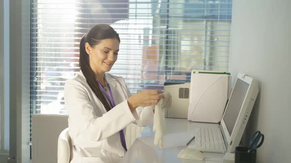 Portrait of Affable Caucasian Doctor Woman Sitting at Desk Making Notes