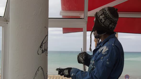 Artist Painting the Mural Outdoors