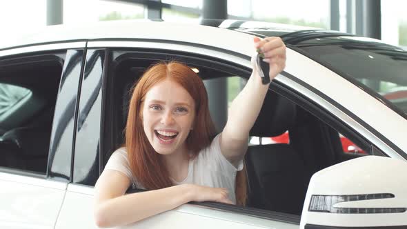 Ginger Woman Smiling at Camera and Showing New Car Key.