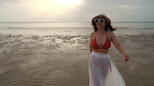 slow-motion of woman in bikini walking on the sea beach