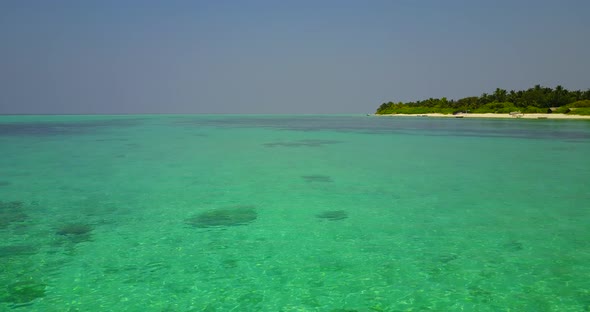 Beautiful birds eye travel shot of a white paradise beach and aqua turquoise water background in 4K