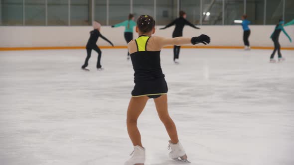 A Little Girl Figure Skater Tries to Perform a Trick but Falls Down and Gets Sad